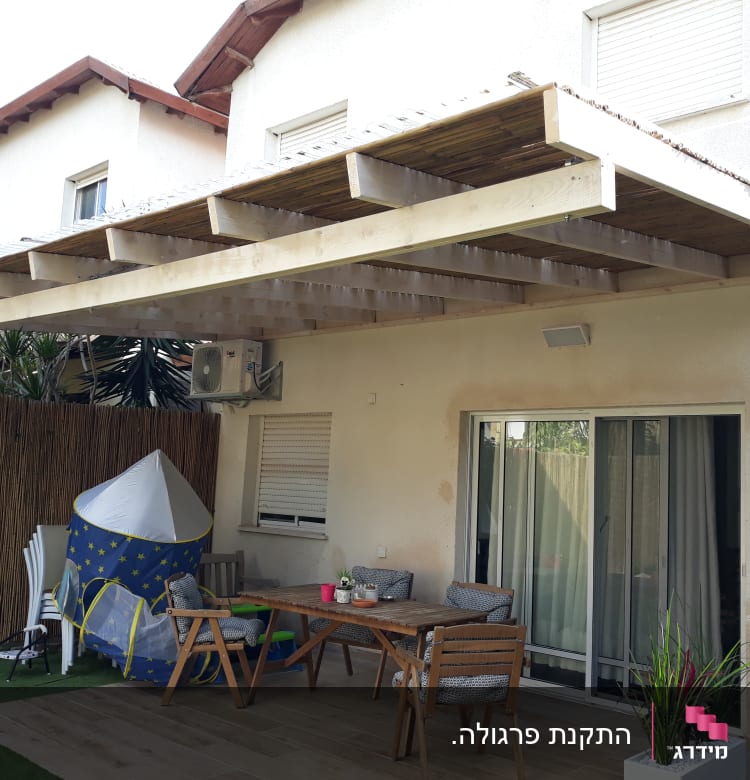 פרגולה מעץ מעל פינת ישיבה בגינה